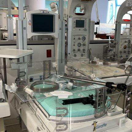 GE Giraffe OmniBed (incubator + radiant warmer) with exam light and scale hardware present